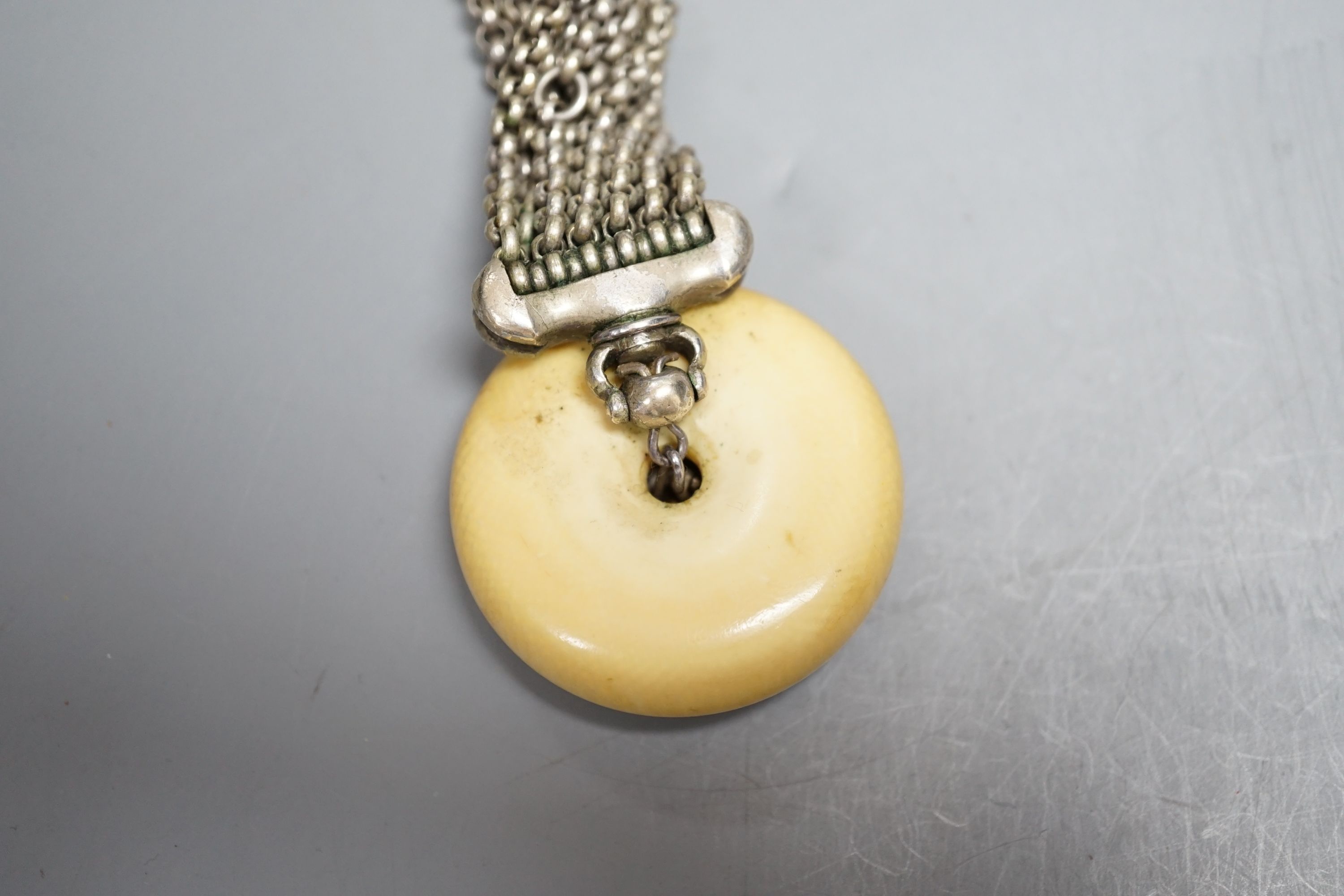 A Japanese ivory Manju netsuke with white metal and base metal suspension brooch
